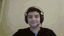 a young boy wearing headphones and a microphone is making a funny face .