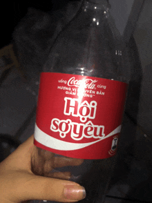 an empty bottle of coca cola has a red label