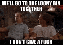 two men are sitting on a couch talking to each other .