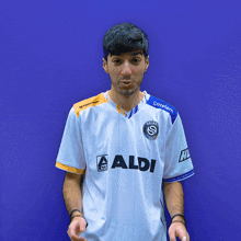 a man wearing a white shirt with aldi on the front