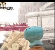 a cartoon character is standing in front of a roller coaster in a video .