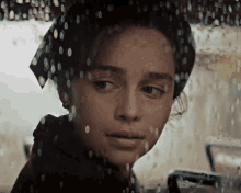 a close up of a woman 's face with rain drops on her face