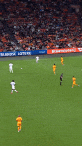 soccer players on a field with a sign that says stadskanaal on it