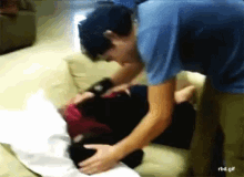 a blurry picture of a man putting a pillow on another man 's lap with the url rbd.gif