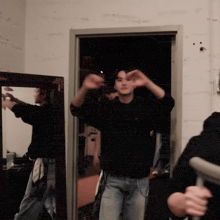 a man in a black sweatshirt is standing in a doorway