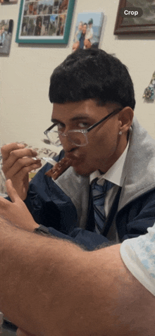 a man wearing glasses is eating a piece of food and the word crop is on the bottom