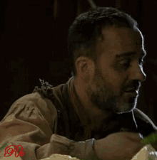 a man with a beard is eating a piece of lettuce with the letter r on the bottom