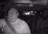 a man with a beard is sitting in the driver 's seat of a vehicle