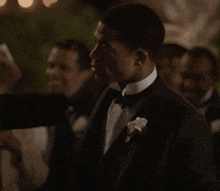 a man in a tuxedo with a white flower in his pocket