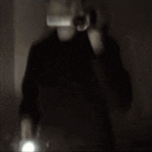 a blurry image of a person holding a flashlight