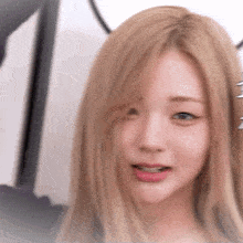 a close up of a blonde woman 's face with a blurred background
