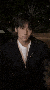 a young man in a black jacket and white shirt