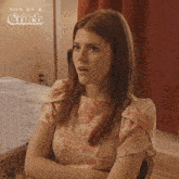 a woman is sitting at a table with her arms crossed and the words son of a critch on the bottom