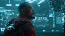 a man in a red shirt is looking at an alien