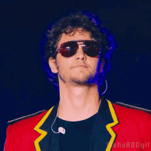 a man wearing sunglasses singing into a microphone