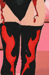 a woman wearing black thigh high boots with red flames