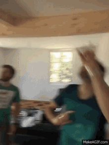 a group of people are dancing in a room with a makeagif.com link