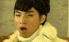 a young man wearing a fur coat is making a funny face with his mouth open
