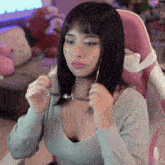 a woman wearing glasses sits in a pink chair with the letters xg on the bottom
