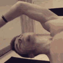a shirtless man is laying on his back with his eyes closed and his arms outstretched .