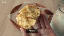 a person is holding a piece of food in their hand with korean writing on the bottom