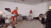 a group of women are dancing in a living room and one of them is wearing boxing gloves