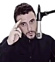 a man in a black shirt stands in front of a microphone