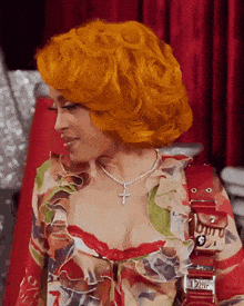 a woman with orange hair is wearing a dior purse