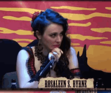 rosaleen s. byrne is sitting at a table with a microphone