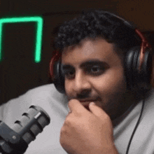 a man wearing headphones is talking into a microphone .
