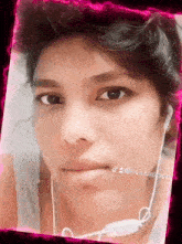 a close up of a person 's face with earbuds around their neck