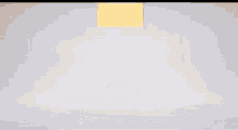 a pile of gold pieces is being thrown into a white box .