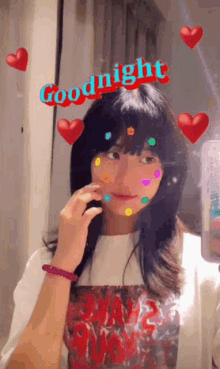 a girl is taking a picture of herself in a mirror with hearts and the words goodnight on her face