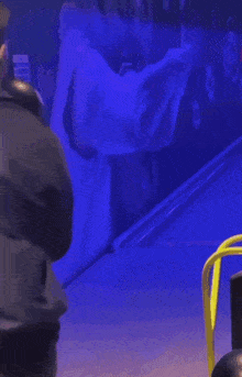 a man is holding a bowling ball in a bowling alley with a purple background