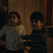 a boy and a girl are standing next to each other