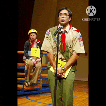 a boy scout stands in front of a microphone with a yellow sign that says 17