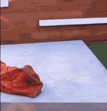 a person is laying on a bed with a sleeping bag on top of them .