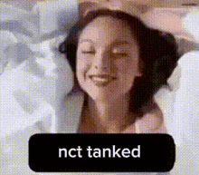 a woman is smiling with her eyes closed and a black button that says `` nct tanked '' .