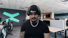 a man wearing headphones and a beanie has the word legend on his hat