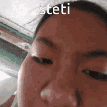 a close up of a woman 's face with the word steti written on her forehead .