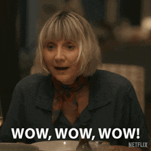 a woman is sitting at a table with wine glasses and says wow wow wow netflix