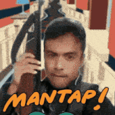 a man is holding a gun with the words mantap written on the bottom