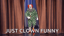 a clown in a green and white polka dot outfit is standing in front of a brown curtain with the caption just clown funny
