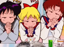 three cartoon girls are sitting at a table with their hands folded and looking at a book .