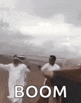 a group of men are dancing in the desert with the word boom written on the bottom .