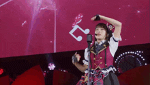 a girl is singing into a microphone on stage .
