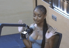 a woman is sitting in front of a microphone in a studio .