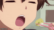 a close up of a person eating food with chopsticks ..