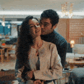 a man is kissing a woman on the forehead in a living room