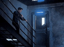 a man is climbing up a set of stairs in a dark room .